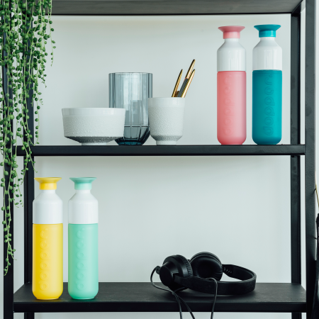 Printed bottles of doppers, on a design shelf with a plant, customizable doppers on Helloprint
